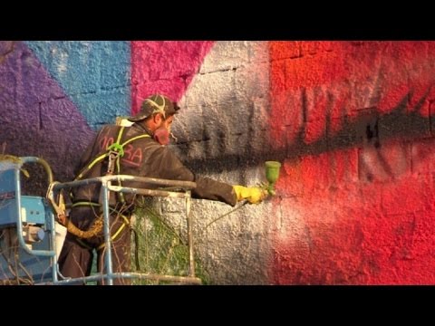 شاهد فنان برازيلي يعمل على إنجاز أكبر رسم جداري في العالم