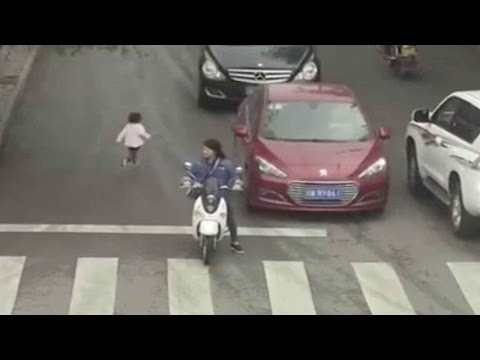 طفلة تعبر أحد الشوارع المزدحمة وتدهسها سيارة دون أن تتأثّر